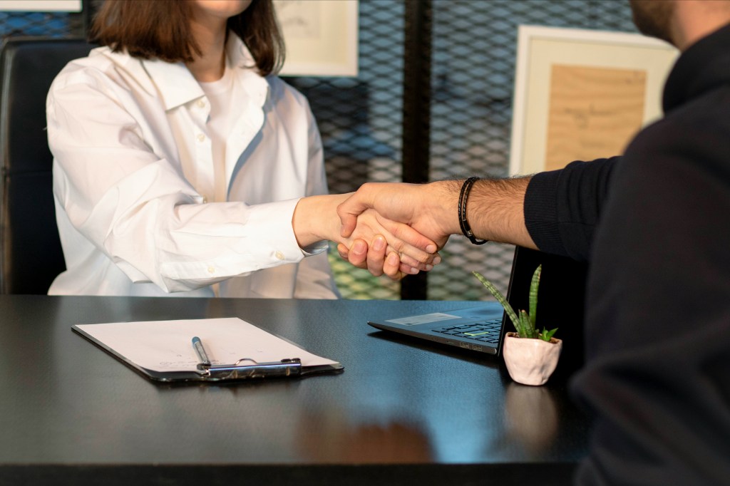 Two people shaking hands in a professional setting